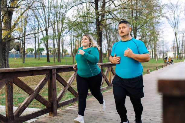 personas con problemas de sobrepeso corriendo en el parque de la ciudad - bridge confidence inspiration motivation fotografías e imágenes de stock