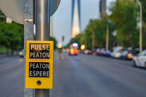 Madrid, spain. august 22 2021. Button for pedestrians at traffic light. Urgency ambulance in the background