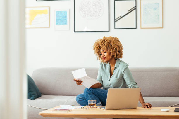 istock Home Office: An Afro-American Woman Looking at a Document 1360438517