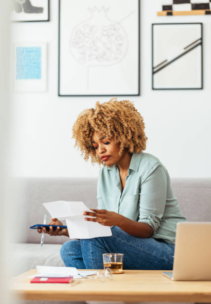 istock Home Office: An Afro-American Woman Looking at a Document 1360438519