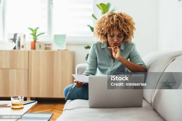 Home Office An Afroamerican Woman Looking At A Laptop Stock Photo - Download Image Now