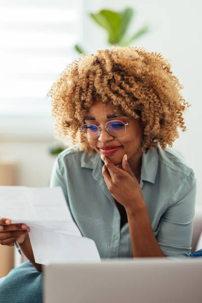 istock Home Office: An Afro-American Woman Looking at a Document 1360438586