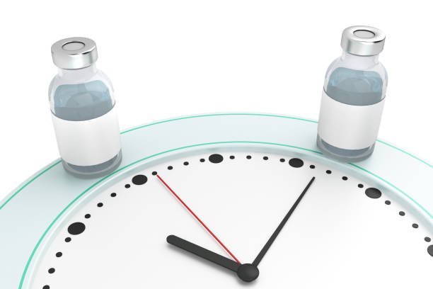two bottles with vaccine on the hour dial stock photo