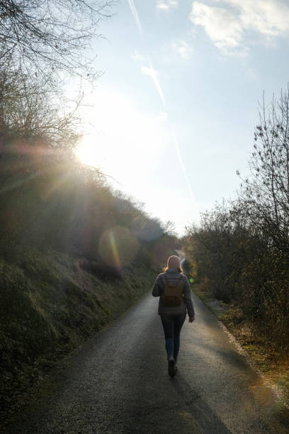 istock Woman walking alone on the road 1360445878