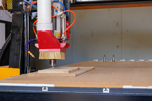 CNC router (computerised numerical control) in use in woodworking shop