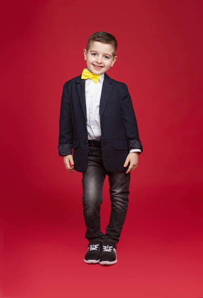 istock Stylish kid in suit smiling for camera 1360448717