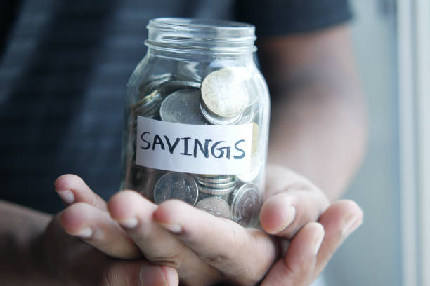 istock young man saving coins in a jar white sited 1360455623