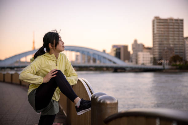 istock Female athlete stretching at riverside 1360456499