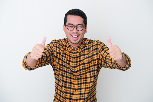 Adult Asian man wearing yellow flannel shirt give two thumbs up