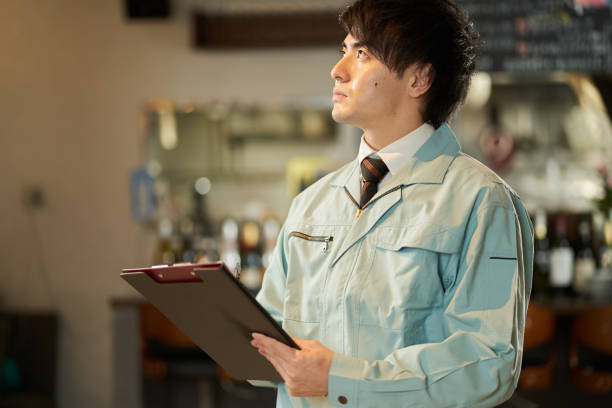 hombre asiático inspeccionando equipos de restaurantes - overalls fotografías e imágenes de stock