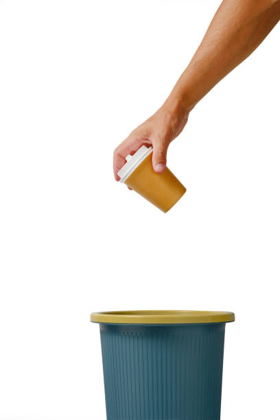 istock Hand on white background throws disposable cup of takeaway coffee into trash.Recycling and ecology. 1360467280