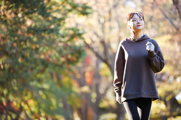 公園で運動している若いアジアの女性 - 競歩 ストックフォトと画像