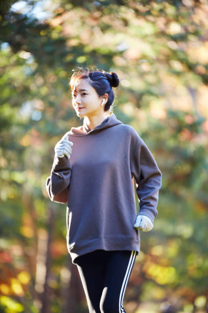 公園で運動している若いアジアの女性 - 競歩 ストックフォトと画像