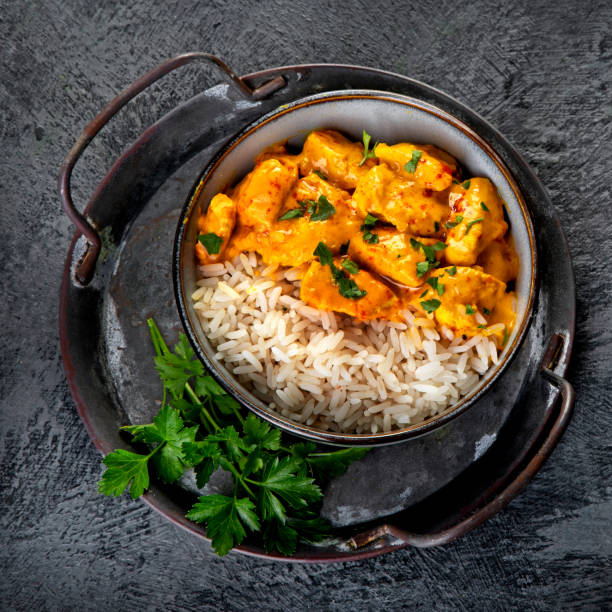 istock Indian butter chicken curry with basmati rice on dark background. 1360470143