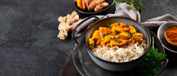 istock Indian butter chicken curry with basmati rice on dark background. 1360470305