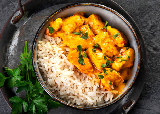 istock Indian butter chicken curry with basmati rice on dark background. 1360470306