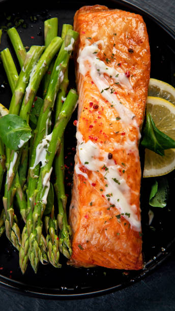 istock Baked salmon with asparagus on gray background. 1360470429