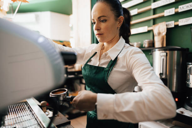 istock Caucasian female barista at work making coffee 1360476565