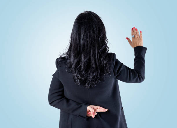 Woman with crossed fingers behind her back stock photo