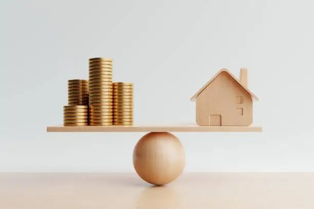 Photo of Wooden house and golden coin on balancing scale on white background. Real estate business mortgage investment and financial loan concept. Money-saving and cashflow theme. 3D illustration rendering