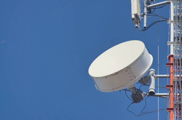 istock Internet towers and transmission equipment on clean blue sky background 1360483928