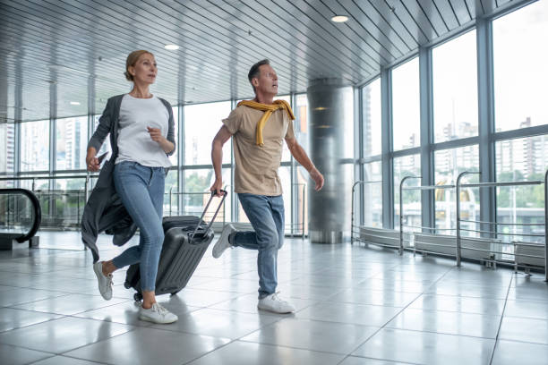 istock Two excited tourists hurrying to catch the flight 1360486585