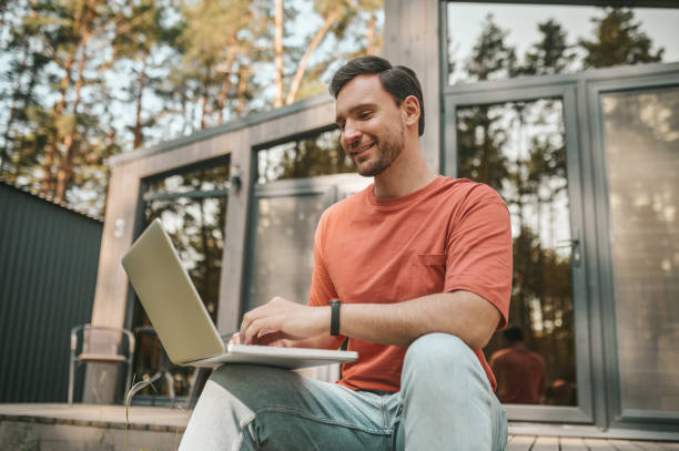 istock Young man feeling positive and working on a laptop 1360487913