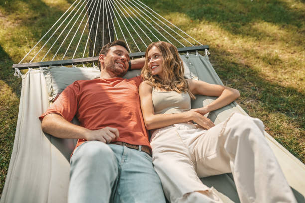 istock A man and a woman lying in a hammock and feeling relaxed 1360488455