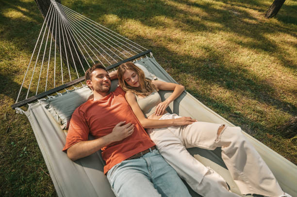 istock A man and a woman lying in a hammock and feeling relaxed 1360488466