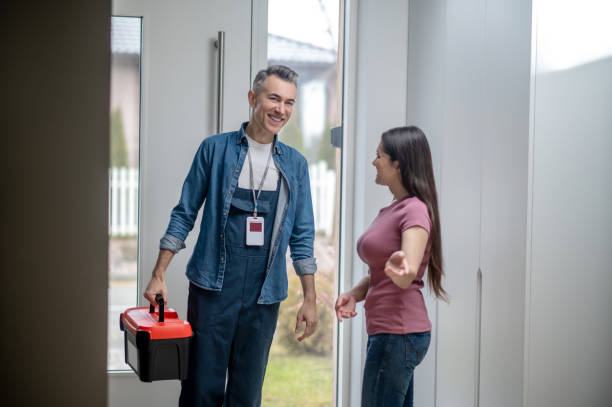 istock Woman inviting man to the house with tools 1360492026