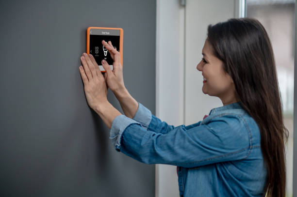 istock Woman touching smart home device choosing mode 1360492055