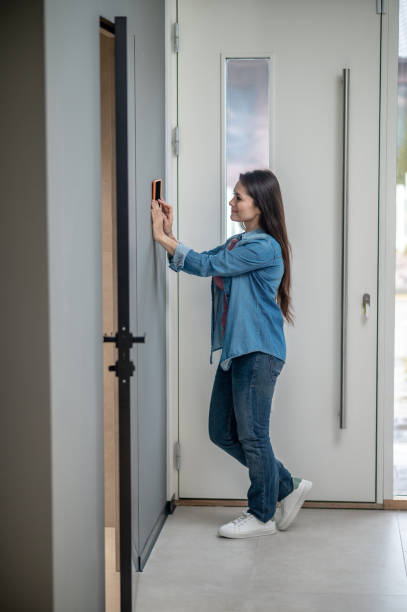 istock Woman standing sideways to camera near smart home device 1360492058
