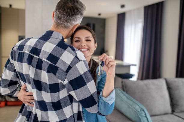 istock Dancing woman with keys and man with back to camera 1360492112