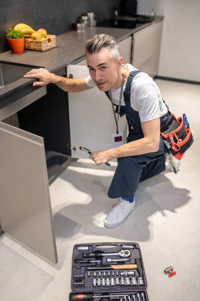 istock Top view of man crouching near sink looking at camera 1360492213