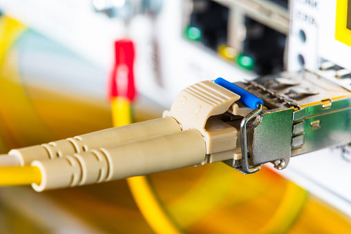 Fiber optic patch cord with gbic connected to switch in data center, selective focus close-up view
