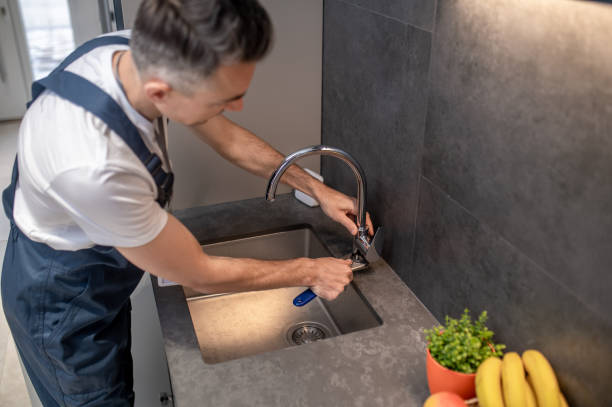 istock Man adjusting water tap with wrench 1360492278