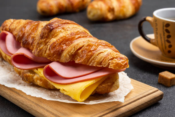 istock Croissant with ham and cheese on board. 1360493450