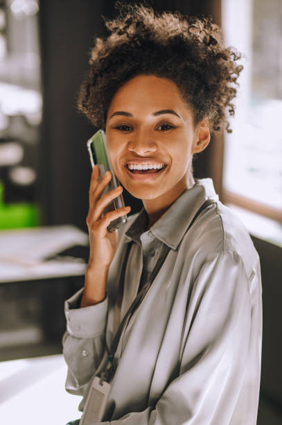 istock Cute smiling dark-skinned woman talking on the phone 1360494561