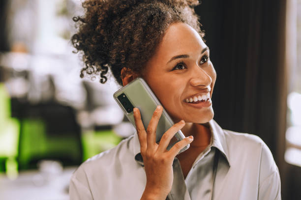 istock Cute smiling dark-skinned woman talking on the phone 1360494568