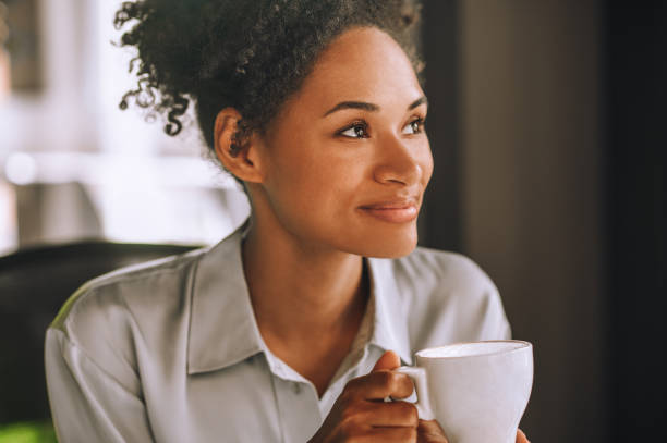 istock Pretty smiling mulatta having coffee and feeling positive 1360494601