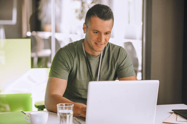 istock Handsome young man working at the laptop 1360494620
