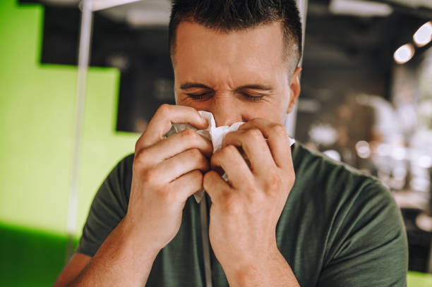 istock Office worker sitting at the table and sneezing 1360494646
