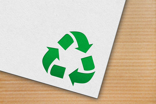 istock Recycle symbol with white paper on a cardboard background 1360494759