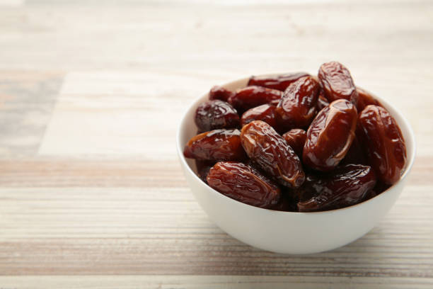 istock White bowl of dried dates on grey background. 1360495540