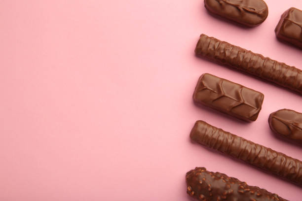 istock Mix of chocolate bars on pink background with copy space. Top view. 1360495638
