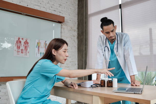 istock Two uniformed young doctors work in medical clinic office. 1360501627