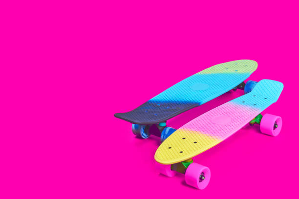 istock Two rainbow plastic Penny board skateboards on crimson background 1360502246