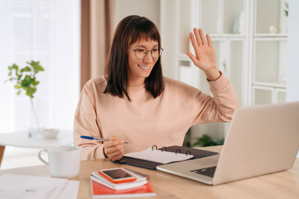 istock Young woman has video call while working remotely from home 1360504081