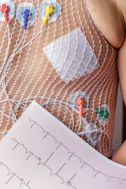 männertorso mittleren alters mit holtermonitor zur herzüberwachung. der holter-monitor wird verwendet, um die funktion des herzens bei normaler aktivität zu überwachen. - pulse trace arrhythmia electrode listening to heartbeat stock-fotos und bilder