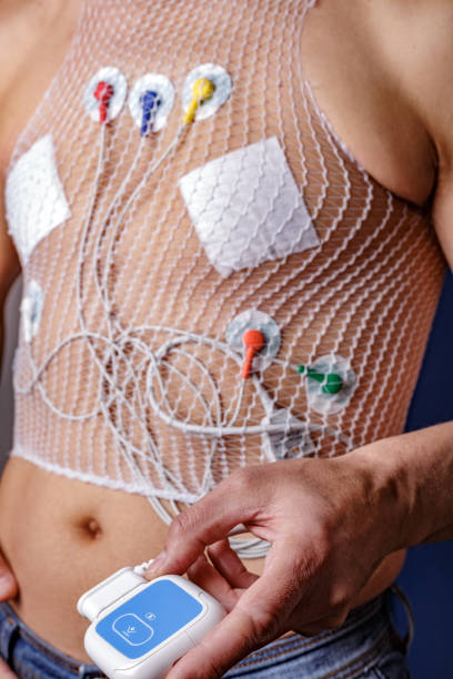 männertorso mittleren alters mit holtermonitor zur herzüberwachung. der holter-monitor wird verwendet, um die funktion des herzens bei normaler aktivität zu überwachen. - pulse trace arrhythmia electrode listening to heartbeat stock-fotos und bilder